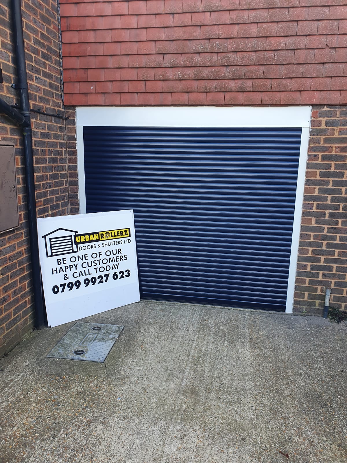 Blue Roller Shutter fitted in brick wall